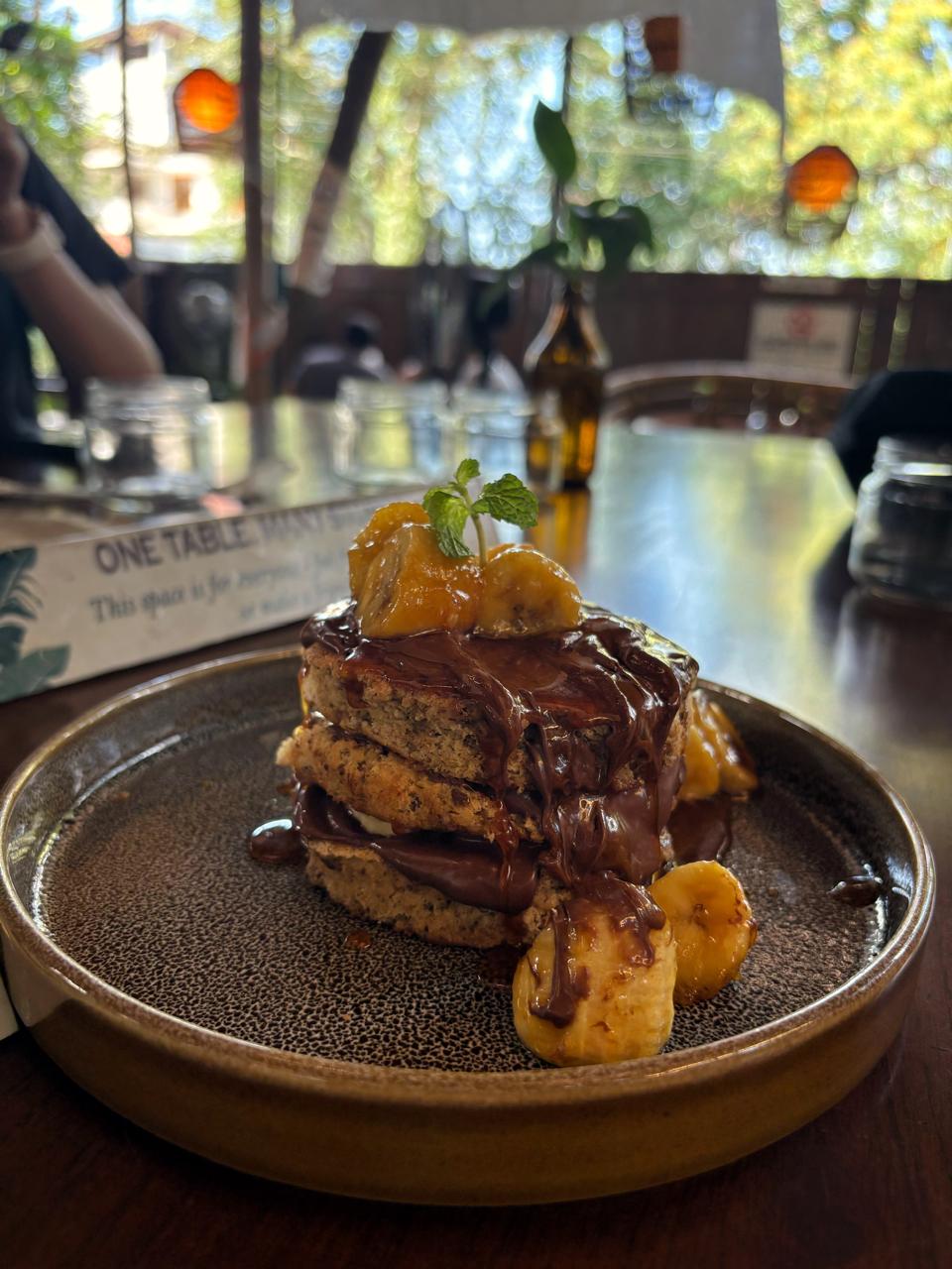 Banana toast with chocolate at a leafy cafe