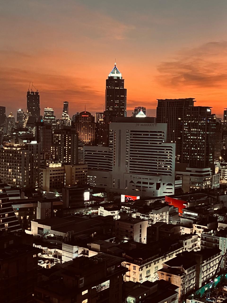 Bangkok skyline glowing beneath an orange sunset